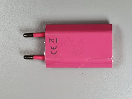 Rosa USB-laddare uppifrån där CE-märkningen syns