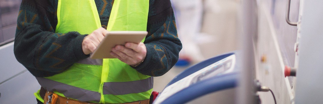 Manlig elektriker med en skärm i handen.