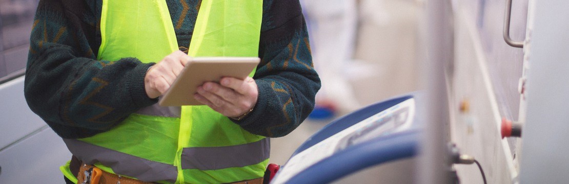 Manlig elektriker med en skärm i handen.