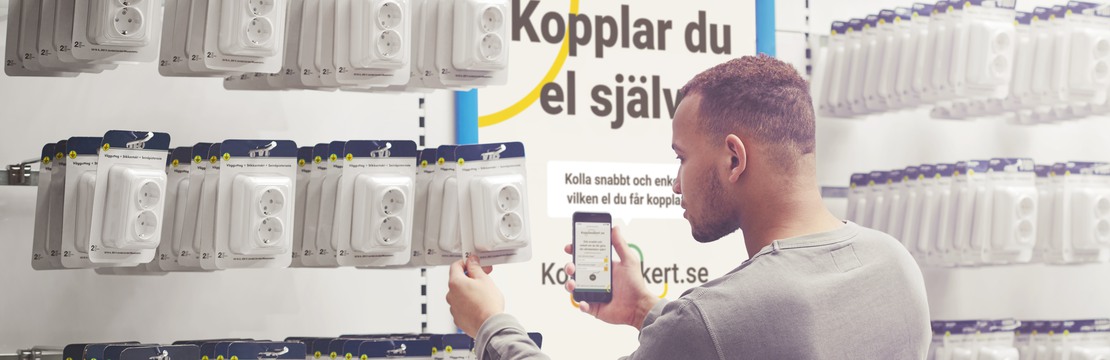 Manlig kund väljer elprodukter i butiksmiljö.