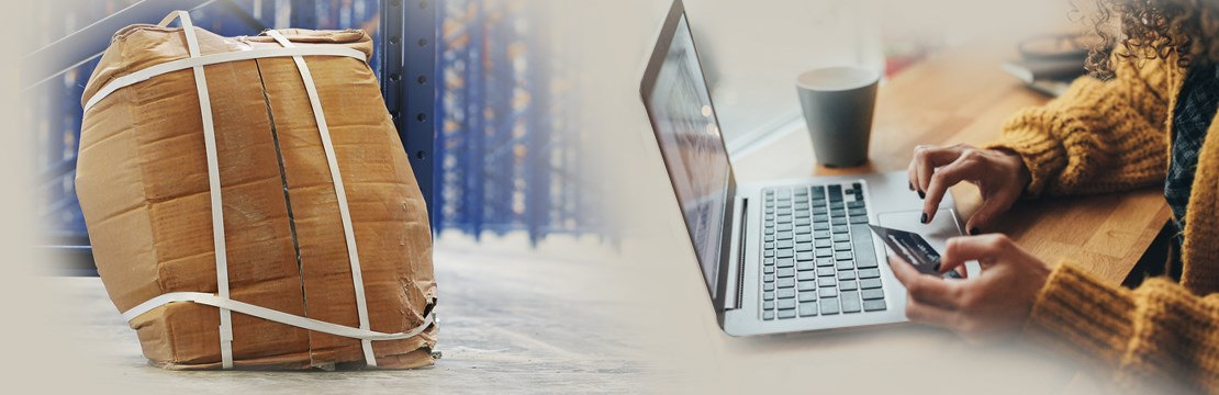 Kvinna vid dator med kreditkort och ett trasigt postpaket i bakgrunden.