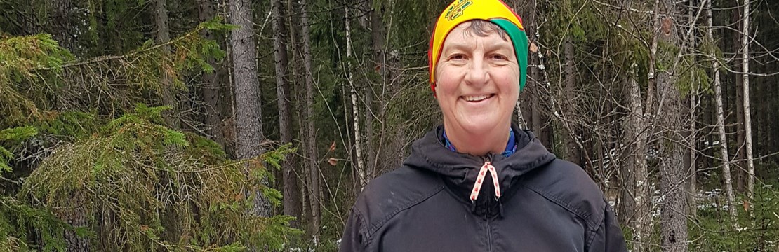 Elisabet Falemo porträttbild med skog som bakgrund.