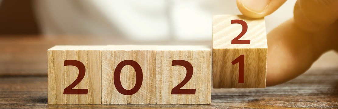 En hand vänder en träkloss som ändrar 2021 till 2022.
