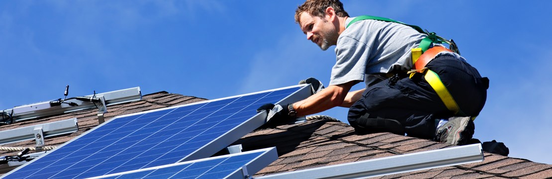 installatör installerar solcellspaneler på villatak