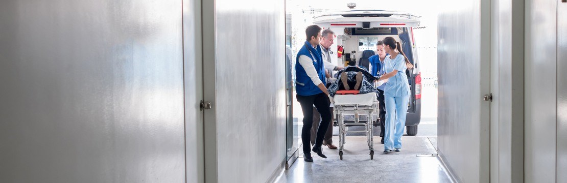 Sjukvårdspersonal tar hand om patient som kommit med ambulans till akutmottagning.