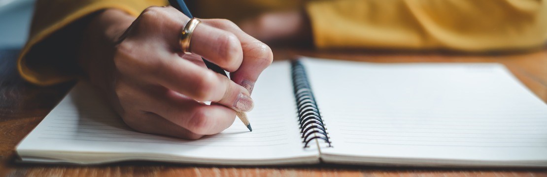 Close up woman hand writing on notebook