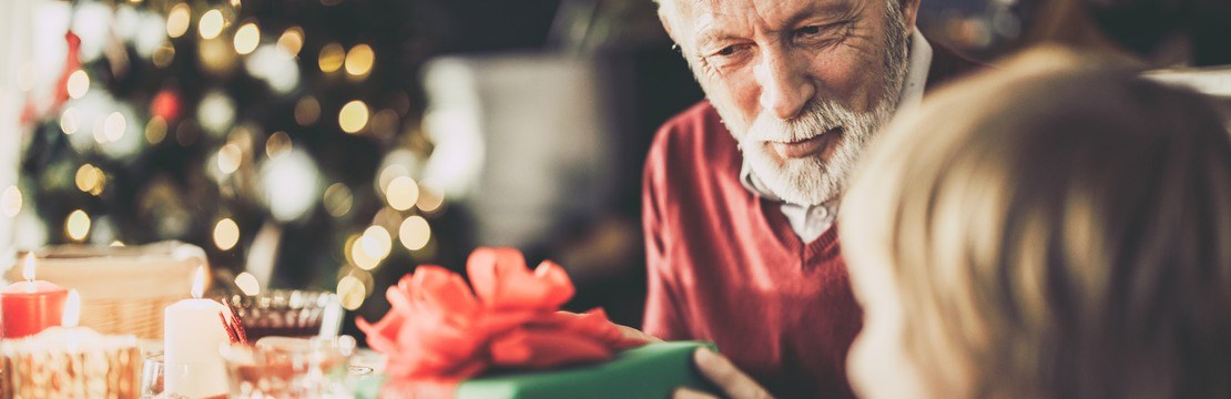 En äldre man får en julklapp av ett barn.