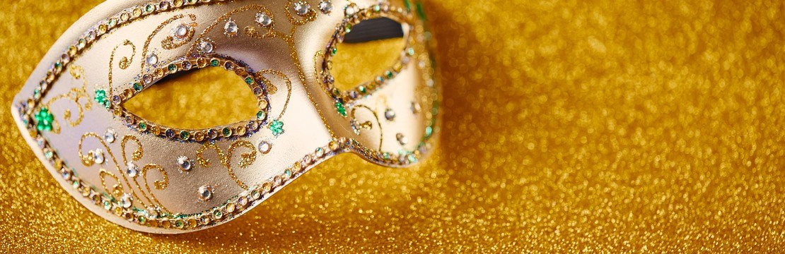 En teatermask på en guldgul bakgrund.