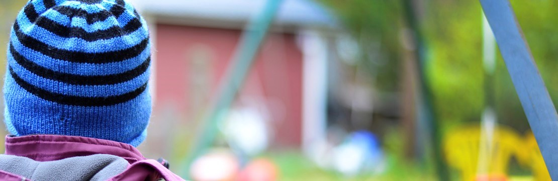 Barn vid staket vid en förskola.