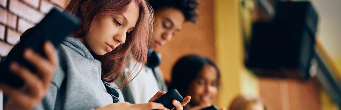 En grupp av ungdomar som använder mobiltelefoner i en skola