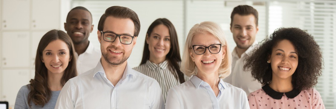 En grupp människor som tittar in i kameran, kontorsmiljö.