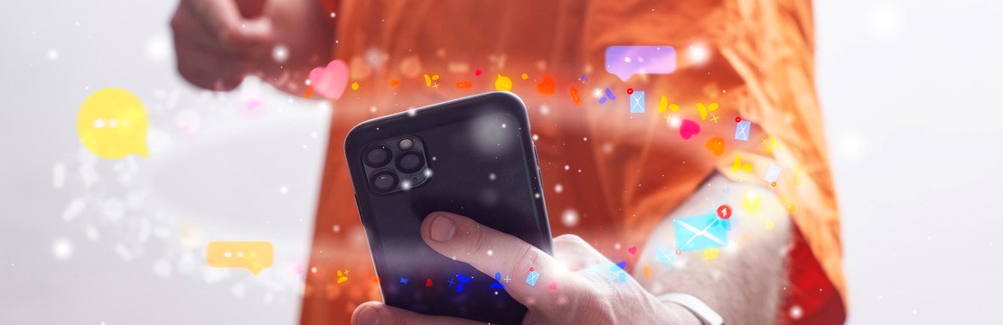 Elev i orange skjorta med en telefon.