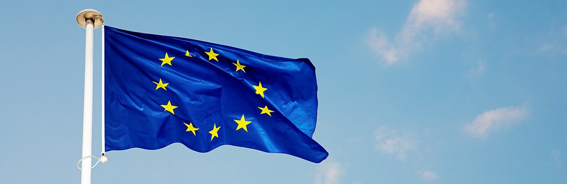 EU-flagga vajar i vinden mot klarblå himmel
