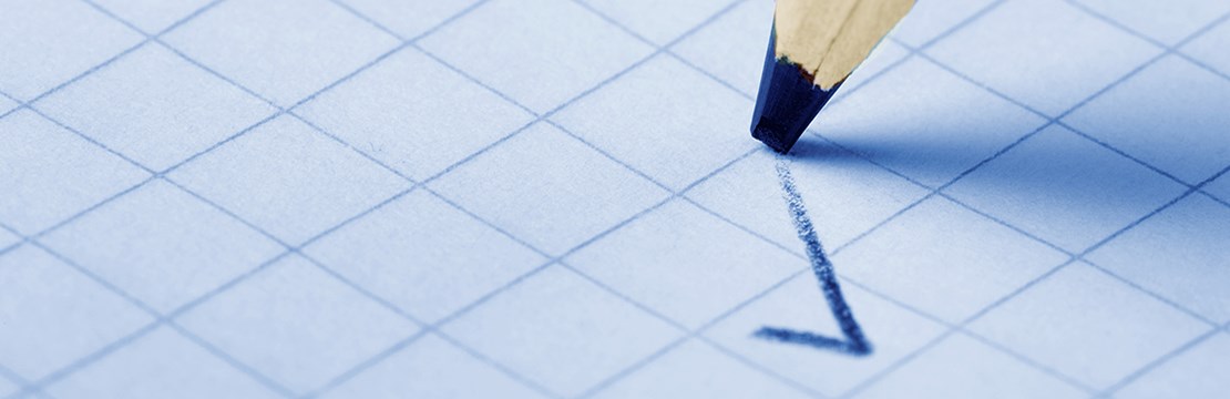 En penna ritar en bock på rutpapper.
