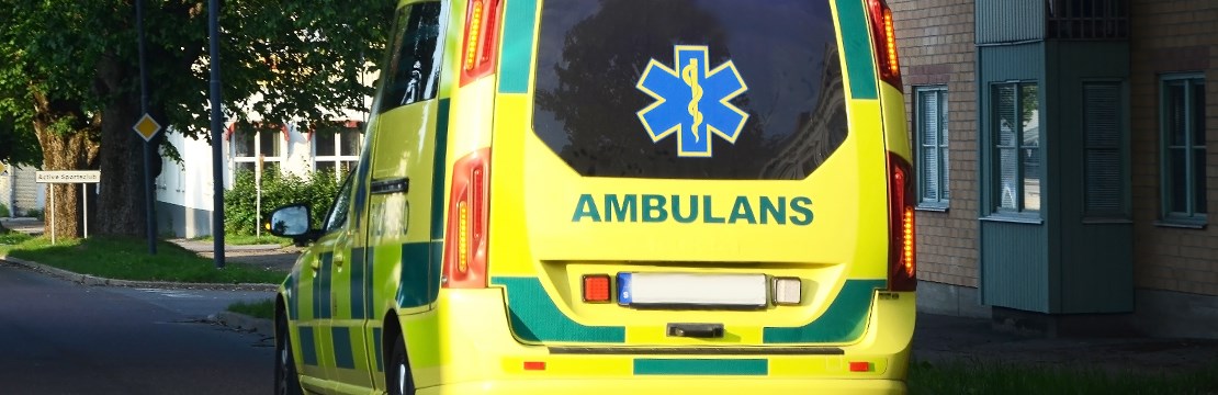Ambulans kör genom bostadsområde.