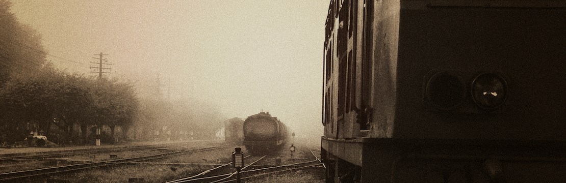 Svartvit bild av en bangård. Flera tåg syns i bilden..
