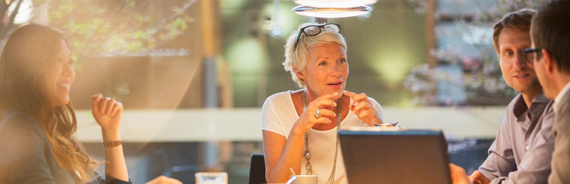 Fyra personer diskuterar runt ett bord.