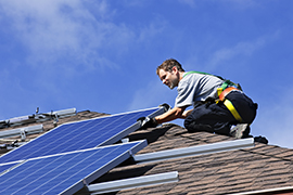 Elinstallatör installerar solceller på tak