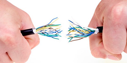 Händer håller i avbruten kabel