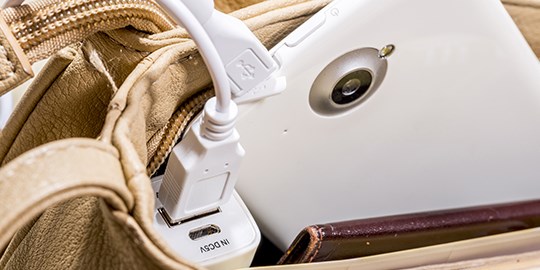 A usb phone charger placed in a bag.