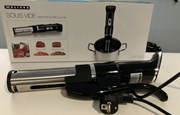 Sous Vide maskin med svart handag och metall framför förpackning