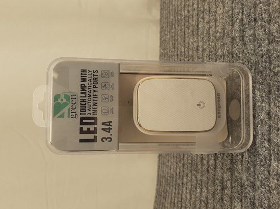 Förpackning av produkten med en bild på en vit nattlampa