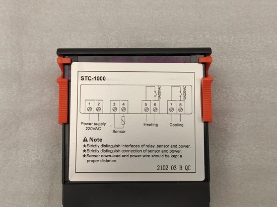 Svart rektangulär plastlåda med en stor vit märkninslapp. Röda detaljer på sidorna. 