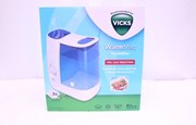 Vit förpackning med märket vicks i en grön triangell. Bild på blå och vid luftfuktare