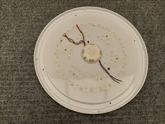 Rund vid lampa av plast. Undersida med sladdar i olika färger