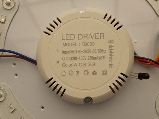 Rund del av lampan i vit plast där produkten märkning finns. 
