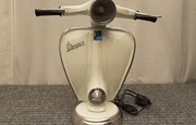 Vit lampa i formen av en mopedfront. Svart kabel