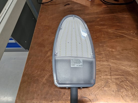 Grån lampa liggande på bänkskiva.