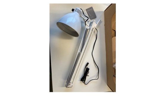 Lampa liggande på skrivbord. 