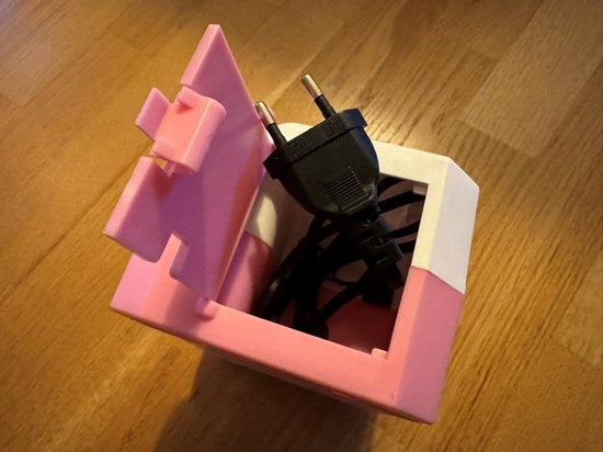 Lucka på sidan som visar strömkabel och dess fack.