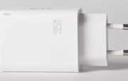 Vit USB-laddare mot grå bakgrund.